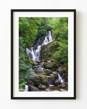 Torc Waterfall flowing through lush green woodland in Ireland