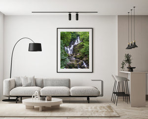 Torc Waterfall descending through leafy Irish woodland into a rocky stream