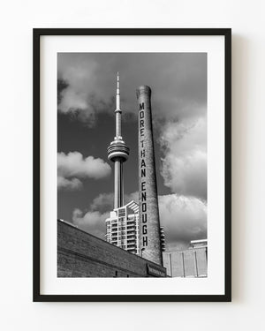 Toronto CN Tower beside a brick smokestack in black and white