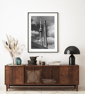 Toronto waterfront smokestack and CN Tower beneath large clouds