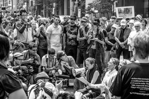 Photographers and demonstrators surrounding a seated speaker at Toronto G20