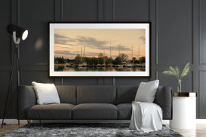 Sailboat masts rising above tree-lined Toronto Island docks at sunset