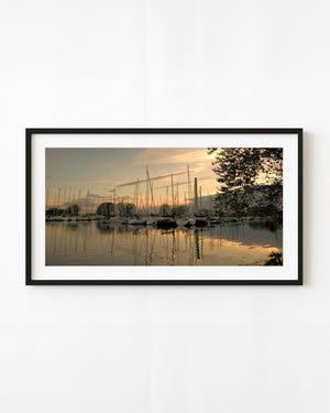 Sailboats reflected in Toronto Island marina beneath a warm dusk sky