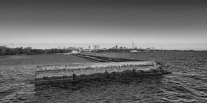 Concrete breakwater leading toward Toronto’s distant CN Tower and skyline