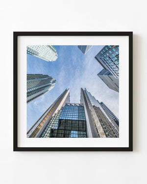 Toronto skyscrapers converging around a blue sky in an upward architectural view