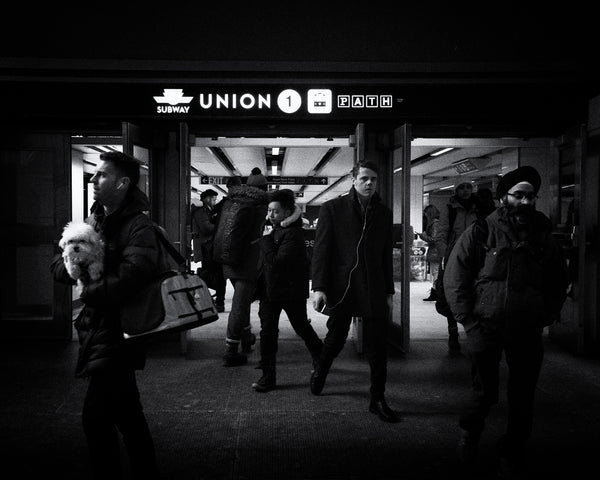Diverse individuals passing by the photographer in Toronto's subway