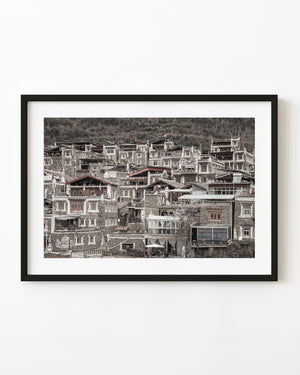 Traditional Tibetan village homes clustered on a wooded hillside.