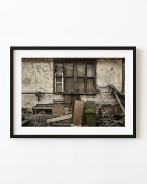 Weathered Transylvanian farmhouse window surrounded by cracked plaster and exposed wood.