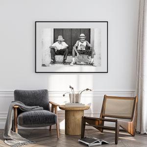 Candid Trinidad portrait with two seated men and a large wooden doorway.