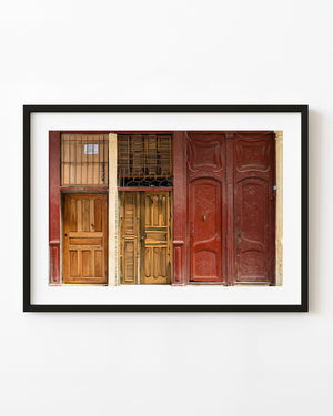 Carved red and natural wood doors on a historic facade in Trinidad Cuba.