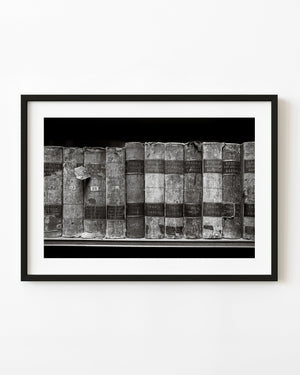 Weathered law books on a Trinity College library shelf in black and white.