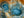 Two blue geothermal pools amid rust-orange and pale mineral textures.