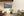 Colour landscape photograph of a brick farmhouse surrounded by cultivated fields.