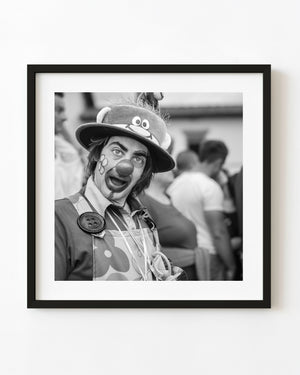 Expressive clown at a Tuscan festival in a black and white portrait.