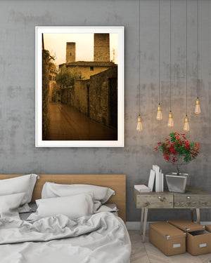 Old masonry and wooden doors line a warmly toned Tuscan street.