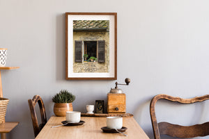 A rustic window with terracotta pots beneath a mossy tiled roof.
