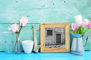 Textured Tuscan stone wall with worn wooden door panels and a simple cross.