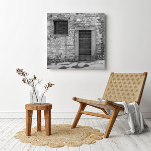 Traditional Tuscan doorway with dark wood and a small cross on its upper panel.