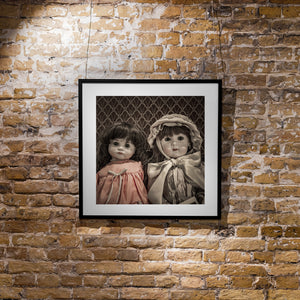 Antique porcelain dolls photographed closely in subdued warm colours.