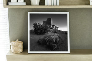 weathered stone building in barren desert terrain monochrome