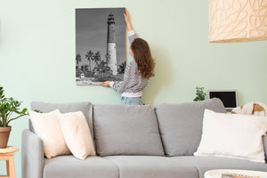 Lighthouse tower framed by palm trees black and white