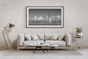 Wide coastal lighthouse scene with palms black and white