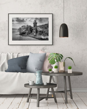 Weathered lighthouse building surrounded by trees near water