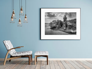 Historic lighthouse structure beside lake with cloudy sky