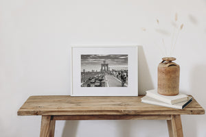 Black and white cityscape showing Brooklyn Bridge daily activity