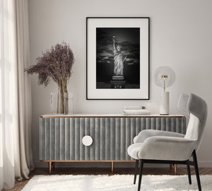 Statue of Liberty standing against dramatic night sky