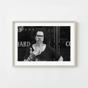 Black and white street portrait of man making hand gesture in Lower Manhattan