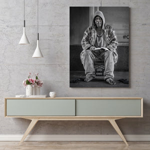 Black and white image of homeless man seated on crate