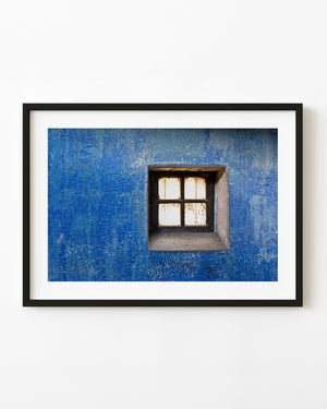 Small four-pane window set in a weathered blue wall at Ushuaia Prison, Argentina