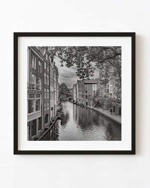 Black and white view of a Utrecht canal lined with historic Dutch houses