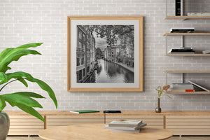 A quiet Utrecht waterway with narrow houses and a distant arched bridge