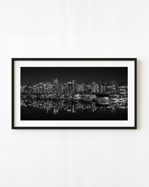 Vancouver skyline and marina lights reflected in calm water at night in black and white