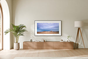 Panoramic desert scene with warm earth tones and a broad cool-toned sky