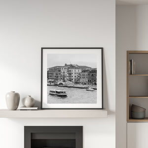 Historic Venice buildings rise above a stone bridge and busy canal