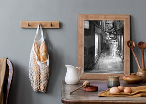 Monochrome street scene with blurred figures moving through a Venice passage