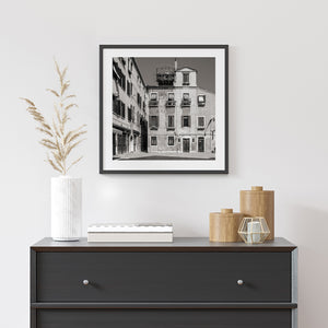 Black and white Venice courtyard scene with shuttered windows and wooden doors