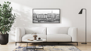 Black and white Venetian shoreline with tall shuttered buildings and mooring posts