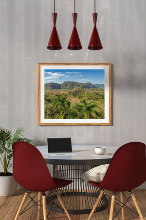 Cuban countryside with green mogotes beneath a blue sky.