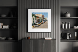 Cuban street scene with parked cars and people along colorful historic buildings