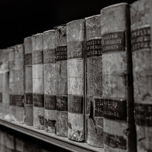 Row of old books on a shelf with visible wear and labels.