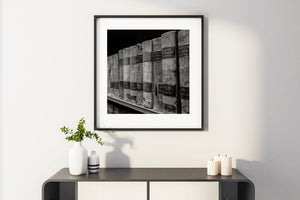 Framed black and white artwork on a wall above a console table with decorative items.