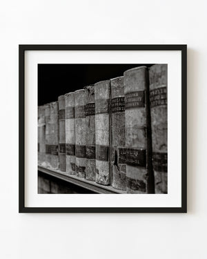 Black and white photograph of worn vintage legal book spines.