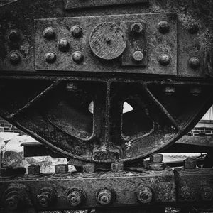 Black and white close-up of weathered heavy machinery.