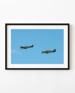 Two vintage RAF aircraft flying against a clear blue sky over Ayr.