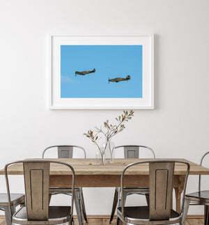Colour aviation photograph of two historic propeller aircraft.