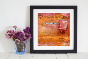 Red fire bucket and weathered painted wall in vivid colour.